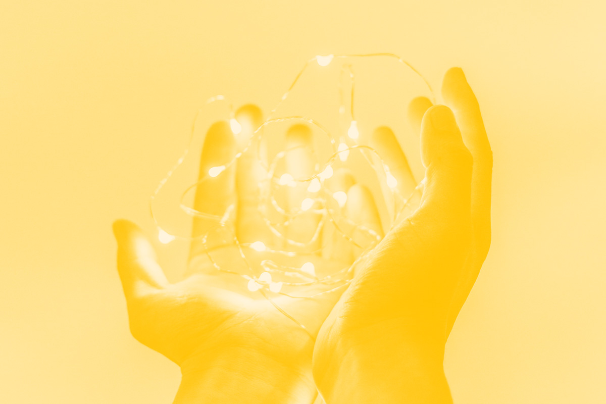 Fotografia de um par de mãos abertas com luzes led alusiva ao conceito de super poder dos designers